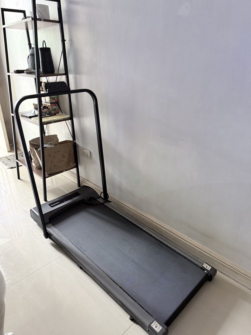 Summer Folding Treadmill Walking Pad (Category: Cardio & Fitness Machines) located in Pasig City. Submitted by shop.gelss (Listing ID 1469973554, Image 1). Description: - Brand: Summer - Type: Compact walking pad / under-desk treadmill - Color: Sleek black finish - Design: Slim profile, ideal for small spaces and under-desk use - Features: Built-in control console on the handlebar - Power: Standard plug attached at the base - Condition: Powers on