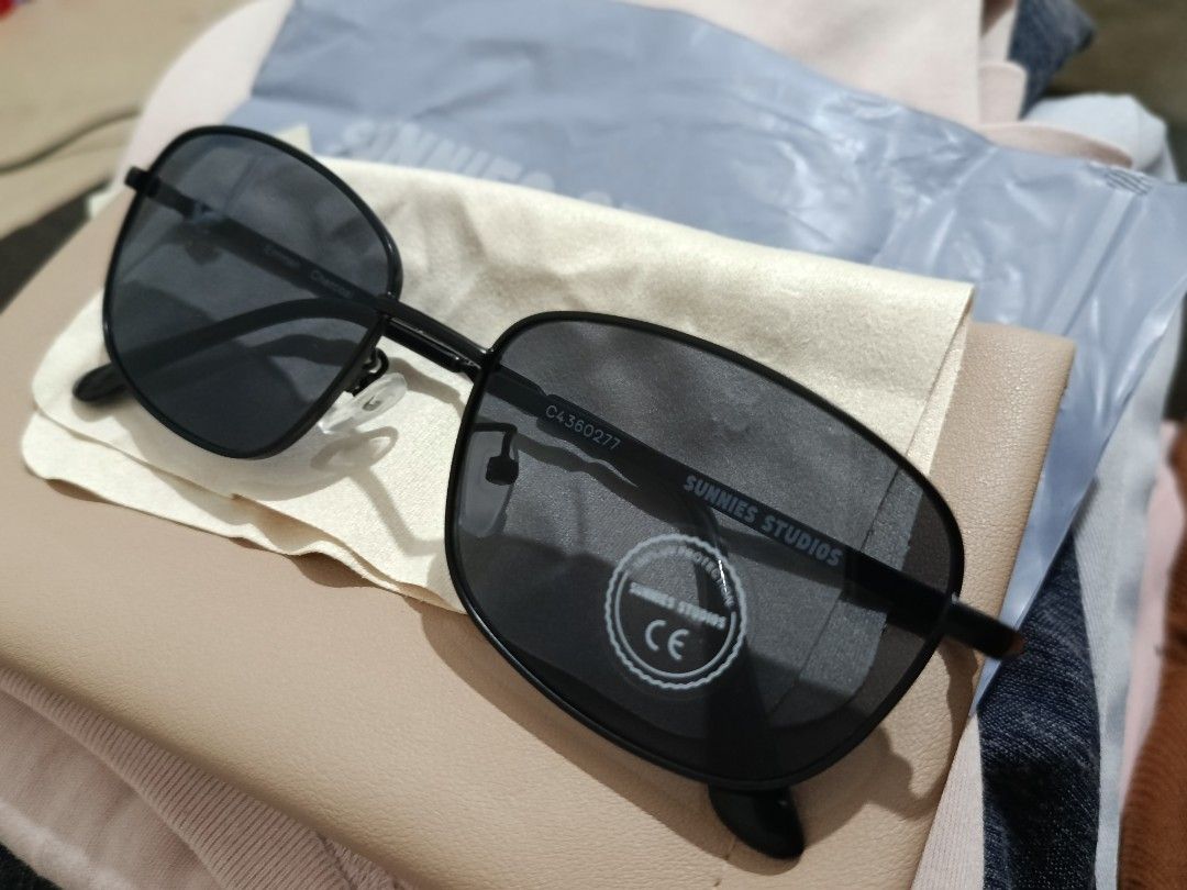 Sunnies Studios Emman Charcoal Sunglasses (Category: Sunglasses & Eyewear) located in Pasig City. Submitted by ruincollections (Listing ID 1470081554, Image 1). Description: - Brand: Sunnies Studios - Model: Emman Charcoal - Condition: Brand new, unworn with original retail tag attached - Frame Color: Black - Lenses: Dark lenses with 100% UV protection - Inclusions: Original branded beige pouch case, ziplock pack of the sunglasses, cloth .