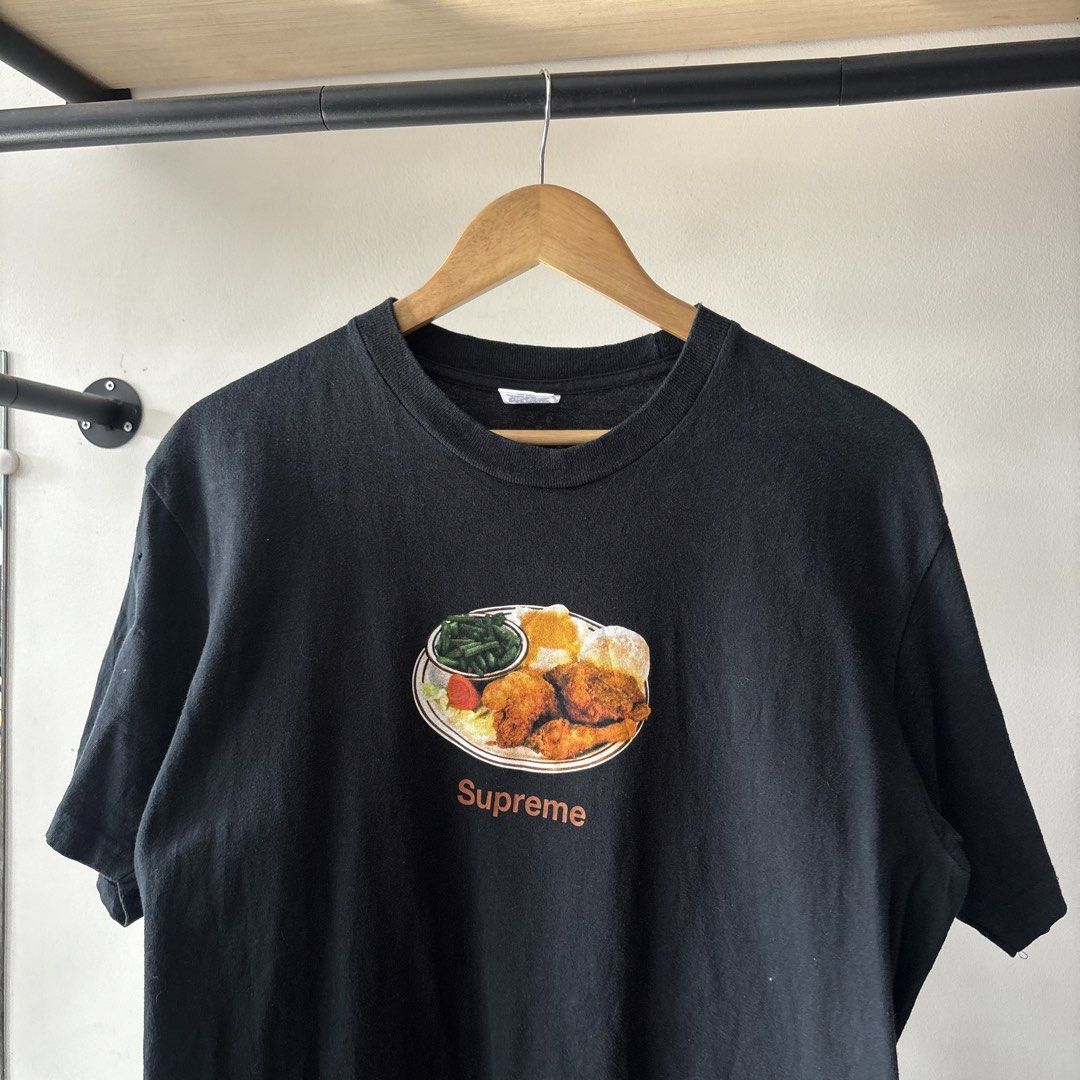 Supreme Fried Chicken Dinner Graphic Tee Black Size M (Category: Tshirts & Polo Shirts ) located in Bambang. Submitted by heats777 (Listing ID 1470020442, Image 1). Description: - Brand: Supreme - Color: Black with fried chicken dinner graphic - Size: Medium - Material: 100% pre-shrunk cotton (Made in U.S.A.) - Style: Classic streetwear - Issue: Last pic.