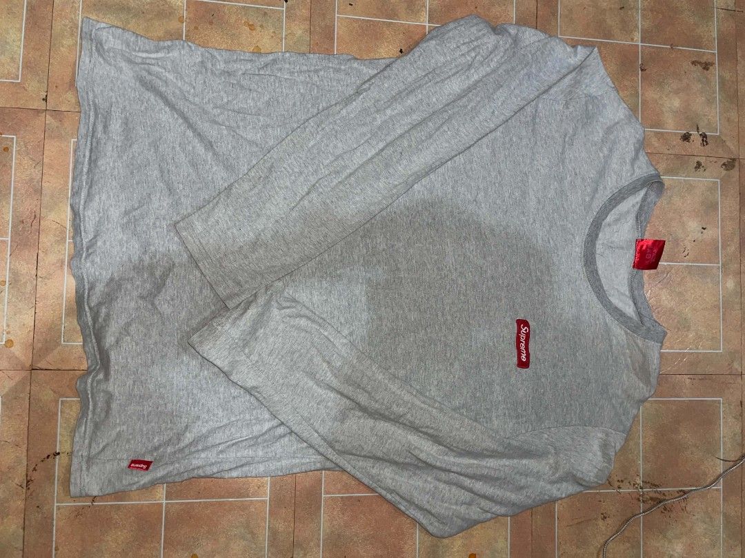 Supreme Grey Long Sleeve T-Shirt (Category: Tshirts & Polo Shirts ) located in Tagbilaran City. Submitted by yxngchris.00 (Listing ID 1469974360, Image 2). Description: - Color: Grey with dark grey crew neck - Branding: Red Supreme box logo on chest, large white Supreme text near back hem, and small embroidered logo on sleeve cuff - Material: 100% cotton, made in Korea - Fit: Regular fit, standard long sleeve - Condition: Brand new/Mint (ready to