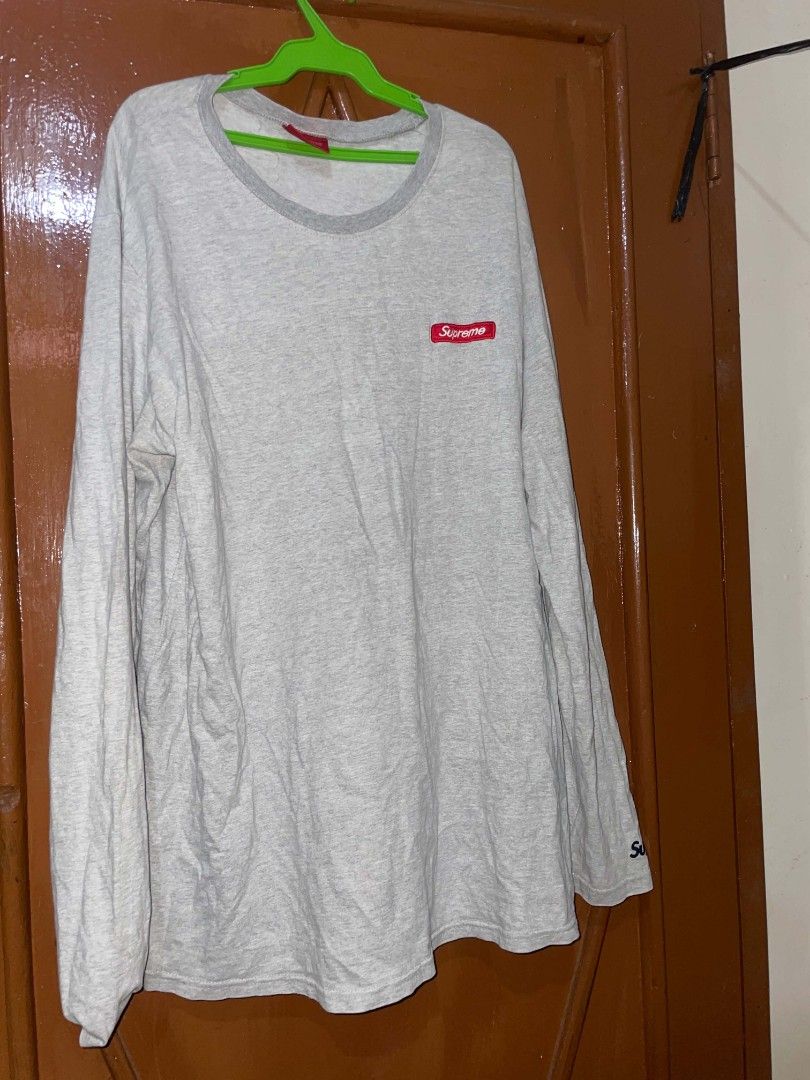 Supreme Grey Long Sleeve T-Shirt (Category: Tshirts & Polo Shirts ) located in Tagbilaran City. Submitted by yxngchris.00 (Listing ID 1469974360, Image 1). Description: - Color: Grey with dark grey crew neck - Branding: Red Supreme box logo on chest, large white Supreme text near back hem, and small embroidered logo on sleeve cuff - Material: 100% cotton, made in Korea - Fit: Regular fit, standard long sleeve - Condition: Brand new/Mint (ready to