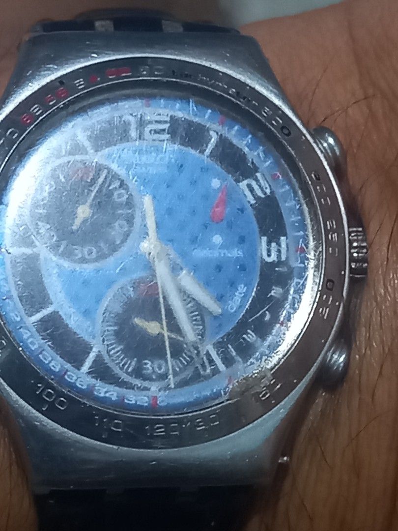 Swatch Chronograph Watch Blue Dial Leather Strap (Category: Men's Watches) located in Subic. Submitted by regiegabriel29 (Listing ID 1470030032, Image 2). Description: - Brand: Swatch Chronograph - Dial: Blue patterned face with large numbers (12, 1, 2, 3) and three sub-dials with vibrant yellow hands - Case & Bezel: Silver-tone metal case equipped with a tachymeter bezel - Strap: Black leather strap with standard metal buckle clasp - Condition: 