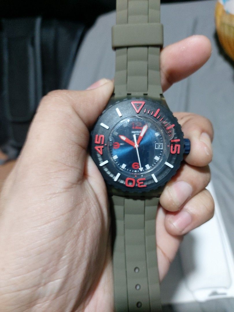 Swatch SUUG400 Swiss Made Plastic Watch (Category: Women's Watches) located in Manila. Submitted by kenriosy (Listing ID 1470049564, Image 1). Description: - Brand: Swatch (Swiss Made) - Model: SUUG400 - Design: Blue dial with vibrant red numbers and hands, paired with a green strap - Condition/Inclusions: Complete with original red packaging box, plastic holder case, and instruction booklet - Price Tag: Original 100 EUR retail tag still attached