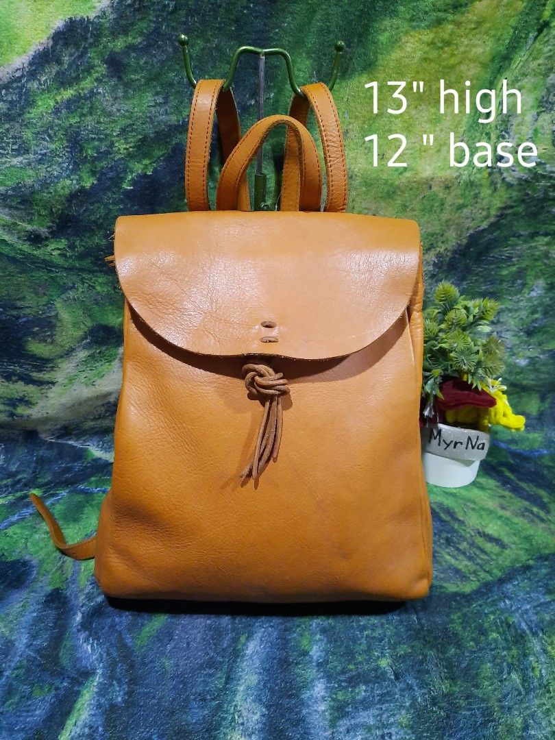 Tan Brown Leather Backpack Drawstring Flap Bag 13x12 (Category: Backpacks) located in Baguio. Submitted by klayblakeb87803 (Listing ID 1470060116, Image 1). Description: - Color: Classic tan brown - Material: Soft leather texture - Closure: Flap with leather drawstring and knot detail - Carry options: Adjustable shoulder straps and top carry handle - Dimensions: Roughly 13 inches high and 12 inches at the base - Interior: Roomy main compartment f