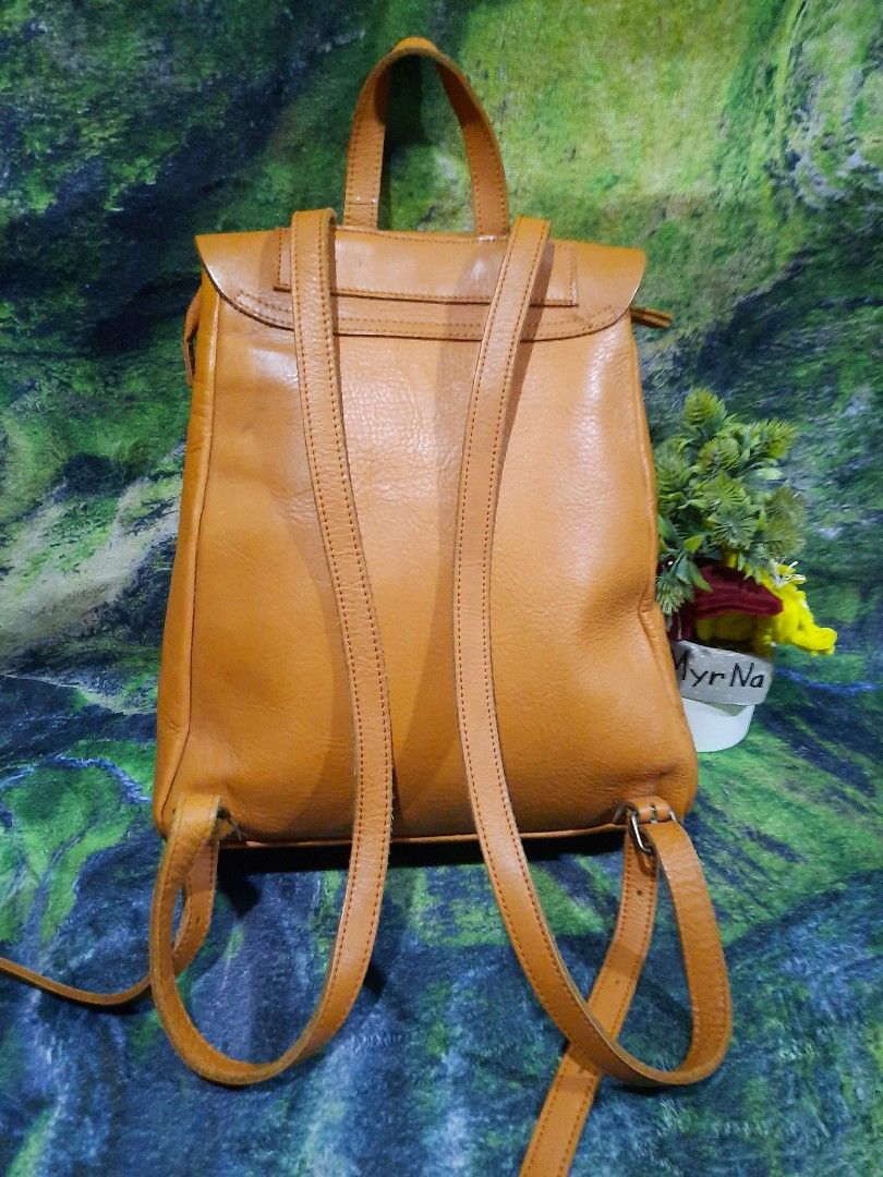 Tan Brown Leather Backpack Drawstring Flap Bag 13x12 (Category: Backpacks) located in Baguio. Submitted by klayblakeb87803 (Listing ID 1470060116, Image 2). Description: - Color: Classic tan brown - Material: Soft leather texture - Closure: Flap with leather drawstring and knot detail - Carry options: Adjustable shoulder straps and top carry handle - Dimensions: Roughly 13 inches high and 12 inches at the base - Interior: Roomy main compartment f