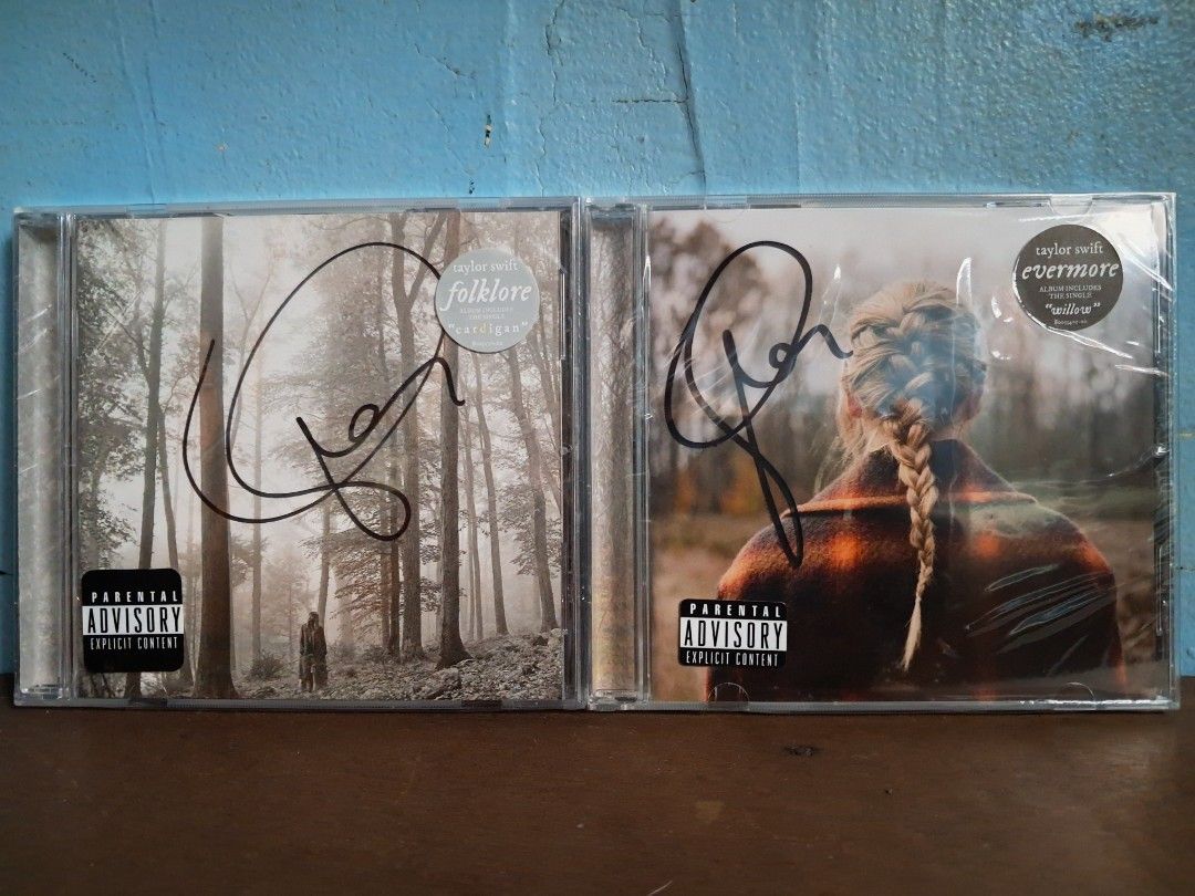 Taylor Swift Folklore and Evermore Signed CD Bundle (Category: CDs & DVDs) located in Nabua. Submitted by bejeweled_13 (Listing ID 1470018627, Image 1). Description: - Authentic Taylor Swift studio albums: folklore and evermore - Genuine hand-signed autographs in black marker on the front covers - Standard jewel case releases from Republic Records - Includes original parental advisory stickers on shrink wrap - Back tracklists and barcodes fully v