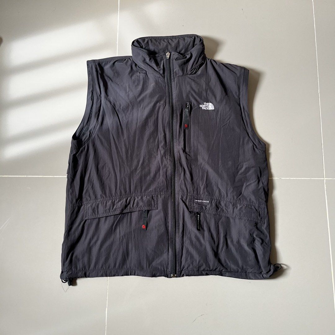 The North Face Black Vest Size 100 M (Category: Vests) located in Toledo. Submitted by collective_stuff (Listing ID 1469957995, Image 1). Description: - Brand: The North Face - Color: Dark Grey - Size: 100 (Fits like Medium) - Material: Durable nylon with breathable mesh inner lining - Closure: Full zip front - Pockets: Multiple front pockets plus a secure zippered chest pocket - Fit: Adjustable drawstring hem - Ideal for: Outdoor adventures, hik