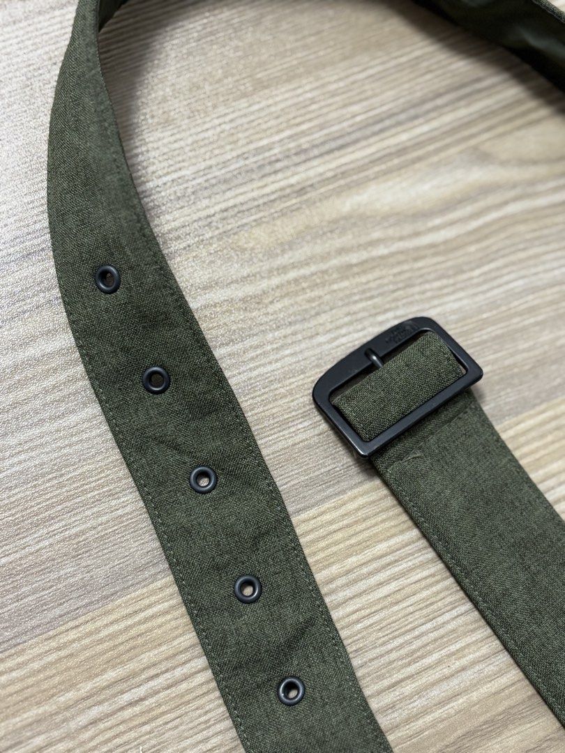 The North Face Green Fabric Belt (Category: Belts) located in Silang. Submitted by lakasthrift1577 (Listing ID 1470074288, Image 1). Description: - Brand: The North Face - Color: Green fabric with dark metal hardware - Design: Classic military style with eyelet holes along the strap - Comfort: Features a smooth inner lining for comfortable wear - Durability: Sturdy construction built to last - Versatility: Great accessory for casual everyday wear