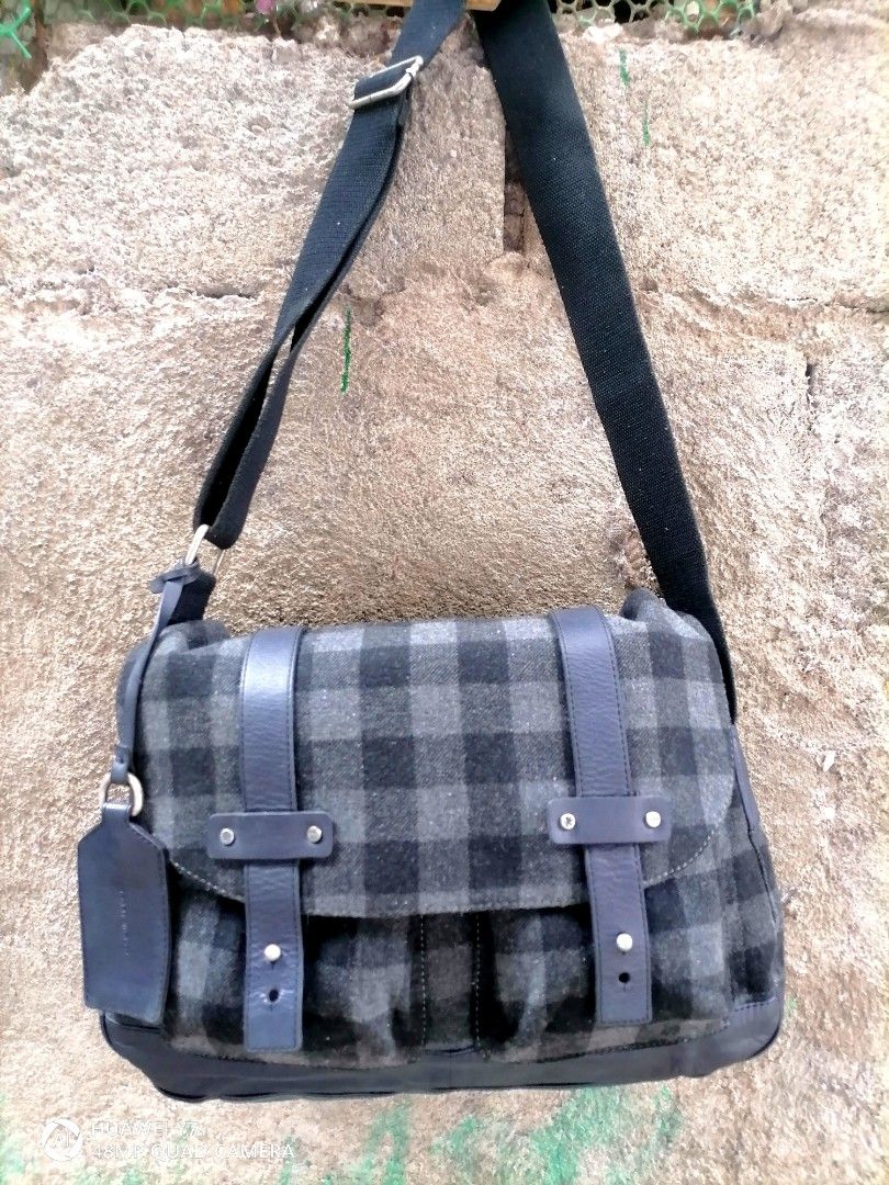 Tommy Hilfiger Wool Plaid Messenger Bag (Category: Sling Bags) located in Naga. Submitted by mrwisethrifter (Listing ID 1469974110, Image 1). Description: - Authentic Tommy Hilfiger messenger bag - Grey and black wool plaid pattern with dark leather trim - Adjustable black fabric shoulder strap for custom comfort - Secure flap closure with stylish leather straps and metal hardware - Spacious main compartment with brown fabric lining and official 