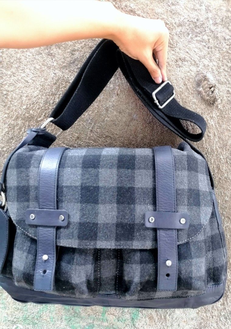 Tommy Hilfiger Wool Plaid Messenger Bag (Category: Sling Bags) located in Naga. Submitted by mrwisethrifter (Listing ID 1469974110, Image 2). Description: - Authentic Tommy Hilfiger messenger bag - Grey and black wool plaid pattern with dark leather trim - Adjustable black fabric shoulder strap for custom comfort - Secure flap closure with stylish leather straps and metal hardware - Spacious main compartment with brown fabric lining and official 
