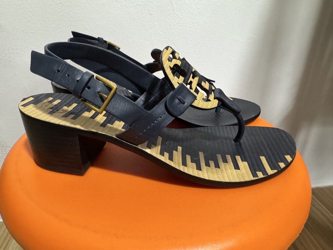Tory Burch Block Heel Sandals (Category: Flats & Sandals) located in Valenzuela. Submitted by sofiasticated.decluttering (Listing ID 1470000331, Image 3). Description: - Brand: Tory Burch - Size: 7M - Color: Navy blue and Gold - Material/Origin: Made in Brazil - Design: Iconic front logo cutout with slingback and adjustable gold-tone buckle - Heel: Solid block heel for stability and all-day comfort - Details: Distinctive patterned footbed - Condi