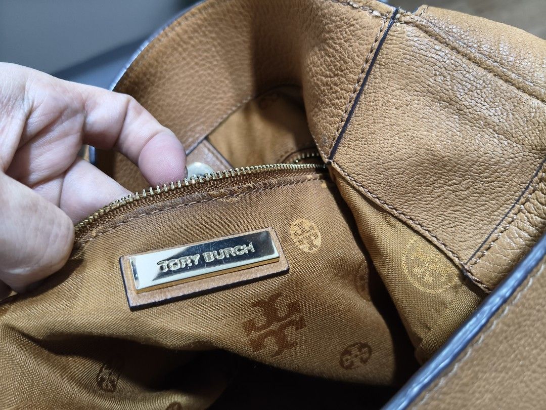 Tory Burch Brody Leather Hobo Bag (Category: Tote Bags) located in Tarlac. Submitted by momma02 (Listing ID 1470139590, Image 3). Description: Tory Burch 'Brody' Leather Hobo Bag in a tan or cognac brown color, featuring soft pebbled leather, a single shoulder strap, a front vertical zipper pocket with a leather pull/tassel, and a polished Tory Burch medallion logo. A slouchy bag yet very spacious..Feels soft to carry, used only a few times.Some 