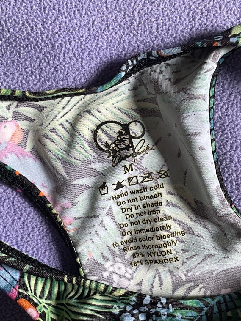 Tropical Leaf Print High Neck Bikini Set Size M (Category: Bikinis & Swimsuits) located in Antipolo. Submitted by chicgrc (Listing ID 1469967948, Image 2). Description: - Size: M - Style: Two-piece swimsuit with high-neck, racerback top and high-waisted bottoms - Design: Tropical leaf and bird pattern top, solid black full-coverage bottoms - Material: Stretchy, comfortable swim fabric - Condition: Clean inside and out, ready to wear.