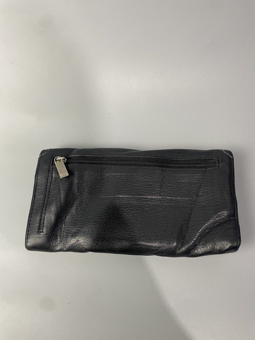 TUMI Black Leather Long Wallet (Category: Wallets & Card holders) located in Veruela. Submitted by blinkban_thrift (Listing ID 1470064807, Image 2). Description: - Authentic TUMI long wallet in genuine black leather with a soft, natural texture - Multiple card slots, ID window, and a secure zippered back pocket - Snap button closure keeps your essentials safe and secure - Clean interior lined with stylish grey fabric - Built-in RFID blocking tech