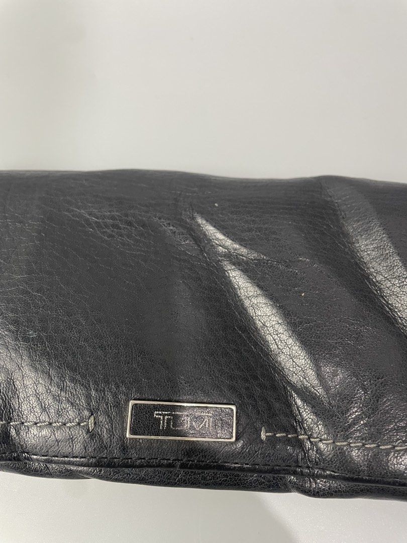 TUMI Black Leather Long Wallet (Category: Wallets & Card holders) located in Veruela. Submitted by blinkban_thrift (Listing ID 1470064807, Image 3). Description: - Authentic TUMI long wallet in genuine black leather with a soft, natural texture - Multiple card slots, ID window, and a secure zippered back pocket - Snap button closure keeps your essentials safe and secure - Clean interior lined with stylish grey fabric - Built-in RFID blocking tech