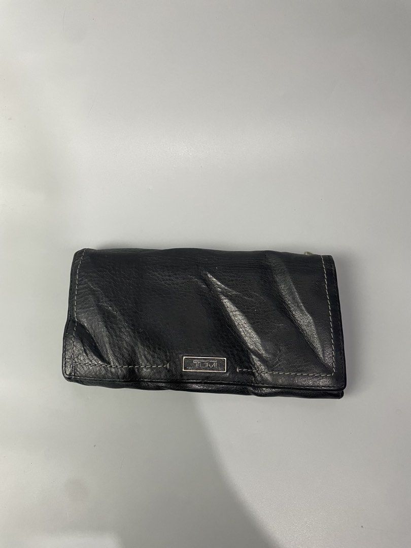 TUMI Black Leather Long Wallet (Category: Wallets & Card holders) located in Veruela. Submitted by blinkban_thrift (Listing ID 1470064807, Image 1). Description: - Authentic TUMI long wallet in genuine black leather with a soft, natural texture - Multiple card slots, ID window, and a secure zippered back pocket - Snap button closure keeps your essentials safe and secure - Clean interior lined with stylish grey fabric - Built-in RFID blocking tech