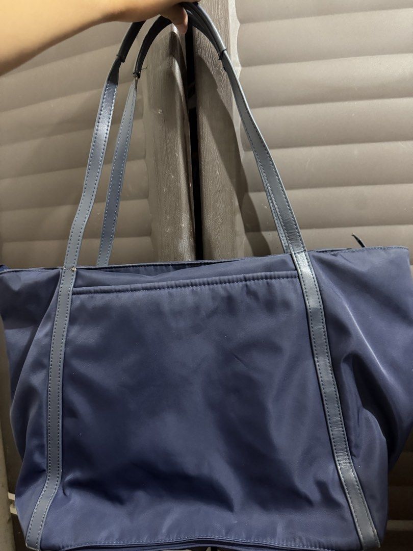 Tumi Blue Nylon Tote Bag with Gold Hardware (Category: Tote Bags) located in Rizal. Submitted by lovegclothingph (Listing ID 1470080307, Image 3). Description: - Brand: Tumi - Material: Navy blue nylon with leather handles and luggage tag - Hardware: Gold-tone logo lettering, zipper closure, and Tumi pull - Interior: Light beige fabric lining - Design: Clean, structured body with double shoulder straps - Condition: Minor wear spots visible near t