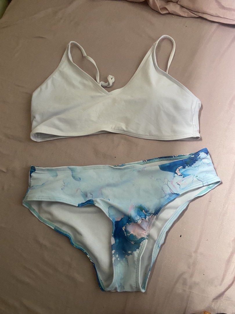Two-piece bikini set with white top and blue marble bottoms (Category: Bikinis & Swimsuits) located in Las Pinas. Submitted by sxo.seya (Listing ID 1469974236, Image 1). Description: - Style: Two-piece bikini set - Top: Plain white with thin straps and tie detail - Bottoms: Blue and pink watercolor marble print - Material: Soft, comfortable fabric - Ideal for: Beach trips, pool days, and vacations.