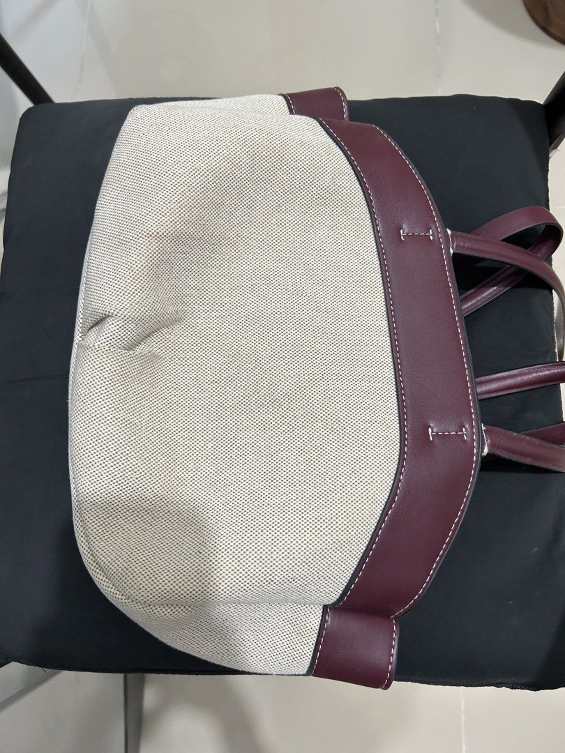 Two-Tone Canvas and Maroon Leather Tote Bag (Category: Tote Bags) located in Quezon City. Submitted by saltynsweetluvr (Listing ID 1470036950, Image 3). Description: - Color & Material: Beige canvas body with deep maroon leather trim - Hardware: Gold-tone accents with a secure top zip closure - Interior: Clean fabric-lined with generous space for daily essentials - Condition: Excellent structure, very clean inside and out.