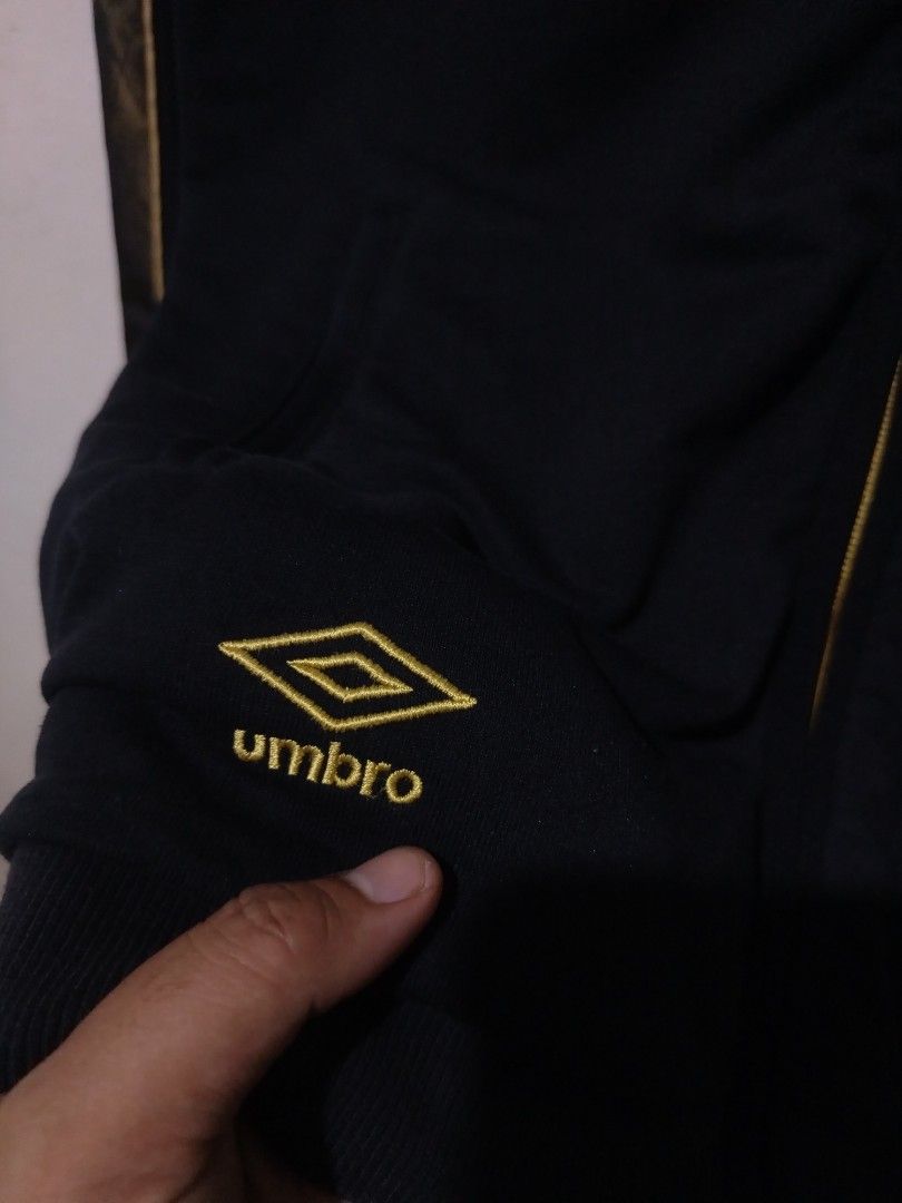 Umbro Black and Gold Track Jacket 1924-2012 (Category: Coats, Jackets and Outerwear) located in Rizal. Submitted by gmpastoffi75031 (Listing ID 1470017681, Image 3). Description: - Brand: Umbro - dimes 21x27.5 - Color: Black with gold trim and gold zipper - Graphics: Number 88 with 1924-2012 on right chest, lion crest on left chest - Details: Small embroidered Umbro diamond logo near hem and patterned taping down both sleeves - Interior: Golden l