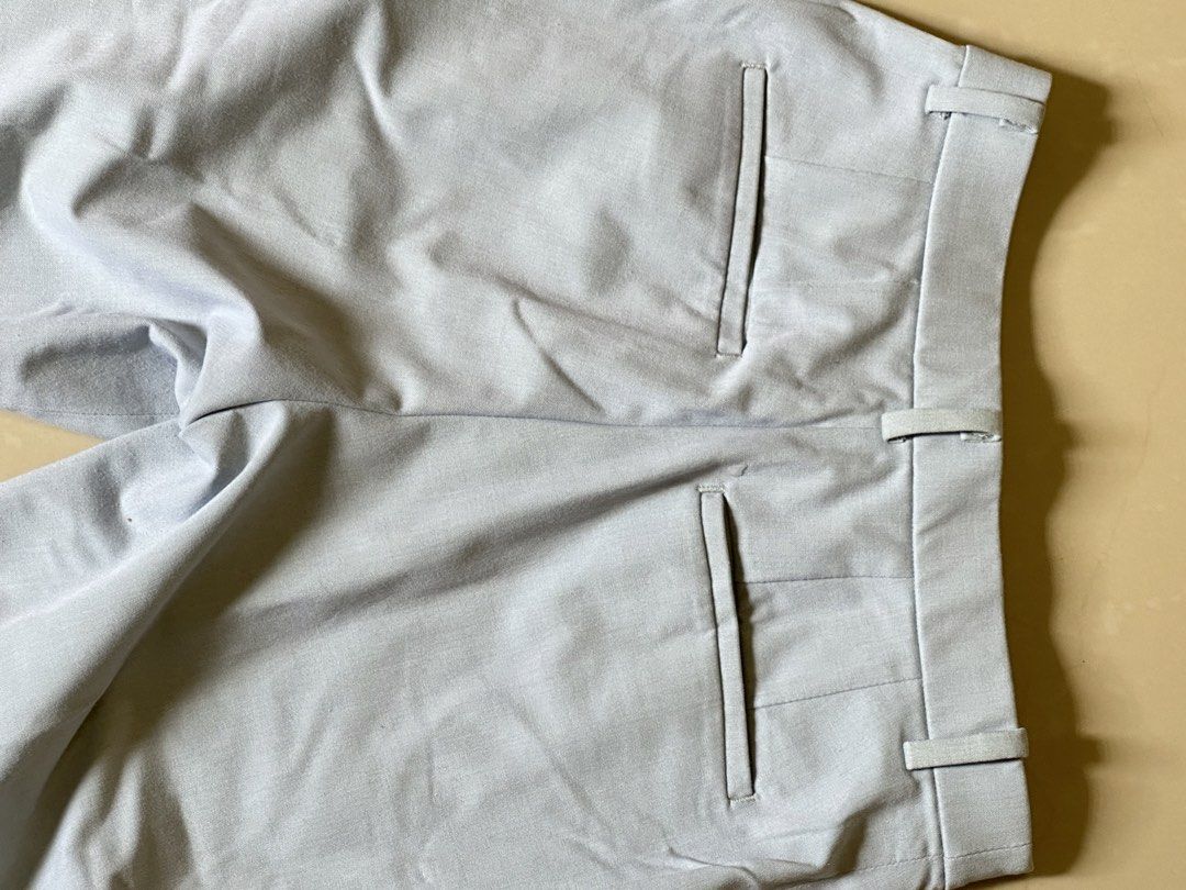 Uniqlo Light Blue Trousers Size S (Category: Other Bottoms) located in Manila. Submitted by lisainthesun (Listing ID 1469959863, Image 3). Description: - Brand: Uniqlo - Color: Light Blue - Size: S (Fits waist: 60-66 cm, Hips: 85-91 cm) - Material: 65% polyester, 31% rayon, 4% spandex (slight stretch) - Fit: Straight leg with professional front center creases - Details: Standard belt loops, zipper fly, functional side pockets, and two back welt p