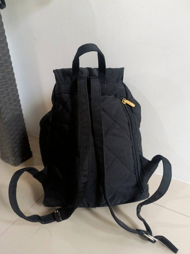 Valentino Christy Quilted Black Nylon Backpack (Category: Backpacks) located in Digos. Submitted by jenepiisid83759 (Listing ID 1470056361, Image 3). Description: - Brand: Valentino Christy - Material: Durable black nylon with a chic quilted pattern - Hardware: Elegant gold-tone accents - Closure: Drawstring with a secure magnetic flap top - Pockets: Front zippered pocket and an internal slip pocket - Interior: Vibrant red fabric lining - Straps: