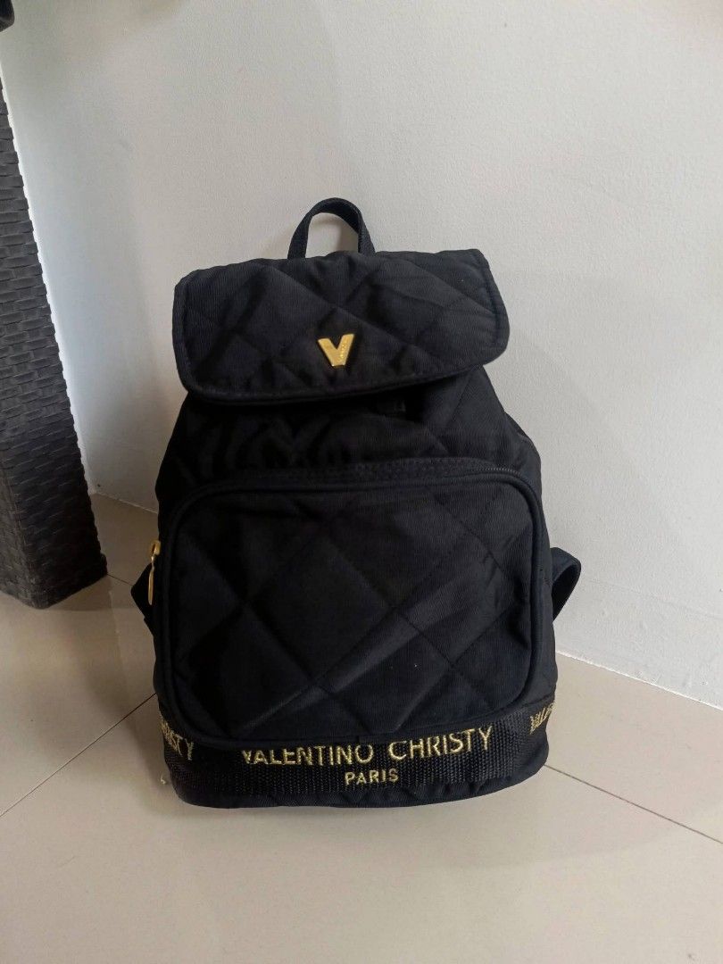 Valentino Christy Quilted Black Nylon Backpack (Category: Backpacks) located in Digos. Submitted by jenepiisid83759 (Listing ID 1470056361, Image 2). Description: - Brand: Valentino Christy - Material: Durable black nylon with a chic quilted pattern - Hardware: Elegant gold-tone accents - Closure: Drawstring with a secure magnetic flap top - Pockets: Front zippered pocket and an internal slip pocket - Interior: Vibrant red fabric lining - Straps: