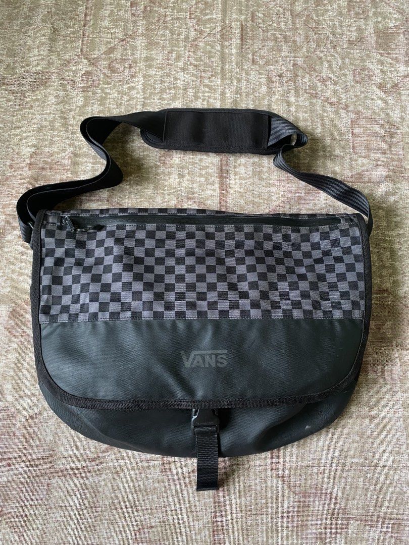 Vans Black and Grey Checkerboard Messenger Bag (Category: Sling Bags) located in Manila. Submitted by diporosmoh43681 (Listing ID 1469975947, Image 1). Description: Vans messenger bag with black and grey checkerboard pattern on the flap. Durable black fabric construction, buckle closure, adjustable shoulder strap with padded section. Zippered pocket on the front flap. Inside features checkered lining, zip pocket, and laptop compartment with velcr