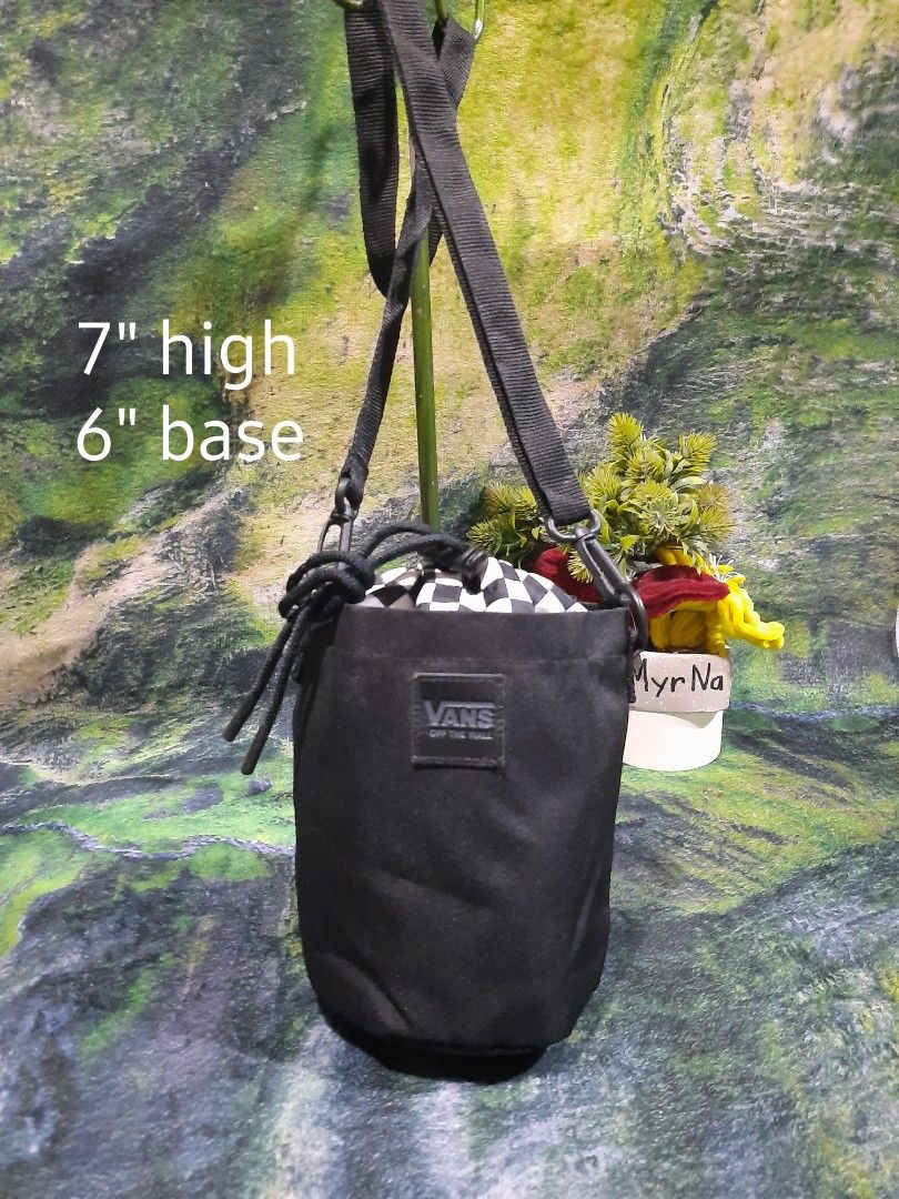Vans Black Checkered Bucket Crossbody Bag (Category: Cross-body Bags) located in Baguio. Submitted by klayblakeb87803 (Listing ID 1470060219, Image 1). Description: - Authentic Vans bucket bag in solid black canvas - Iconic checkered drawstring top closure - Compact size: 7 inches high with a 6-inch base - Adjustable black shoulder strap with sturdy clips - Vans logo patch on the front and brand tag inside.