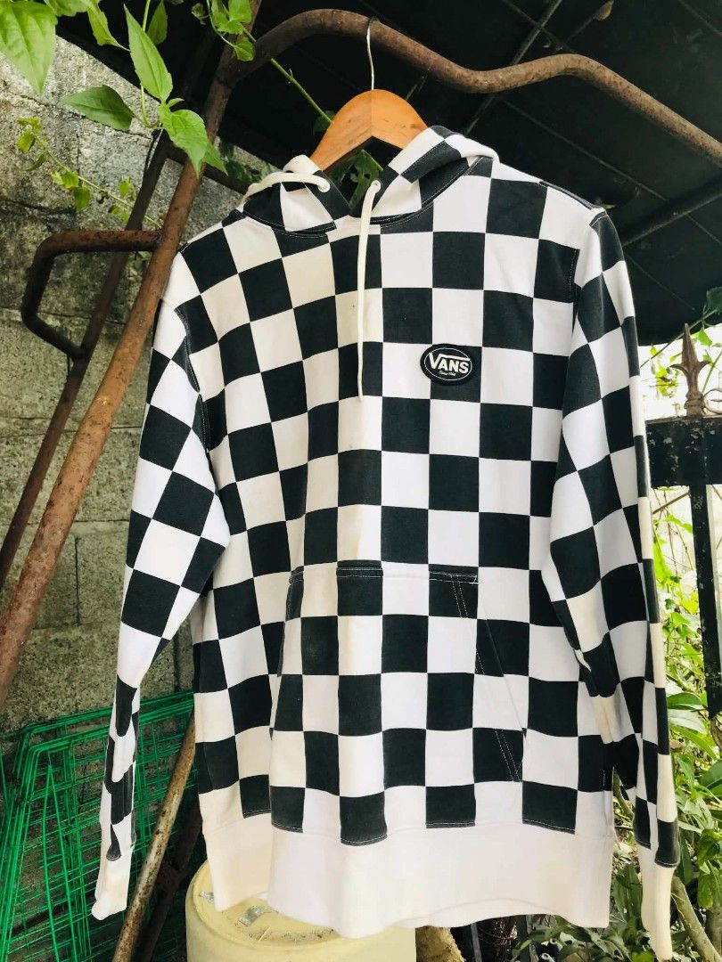Vans Checkerboard Hoodie Black White (Category: Hoodies) located in Camiling. Submitted by dinurobongtubol (Listing ID 1470014702, Image 1). Description: - Authentic Vans checkerboard hoodie in classic black and white - Features a front kangaroo pocket and adjustable drawstring hood - Iconic oval Vans logo patch on the left chest - Comfortable ribbed cuffs and hem - Interior tag shows style number VN0A3QTSOPZ and date 10/2018.
