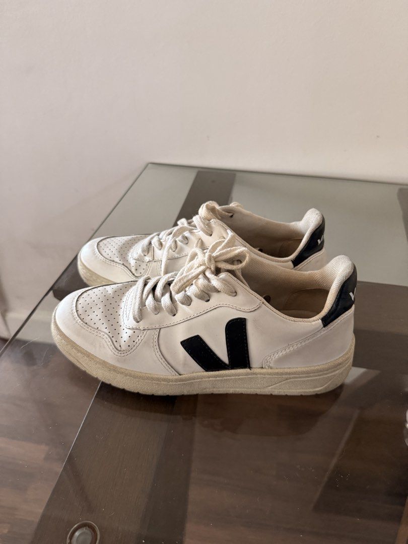 Veja V-10 Sneakers (Category: Sneakers) located in Pasig City. Submitted by thewendynator (Listing ID 1469984766, Image 2). Description: - Brand: Veja V-10 - Color: White with black side logo and heel tab - Size: EU 37 / US 6 / UK 4 - Material: Leather upper with perforated toe box and flat cotton laces - Origin: Made in Brazil - Condition: Normal signs of wear on soles and leather uppers - Style: Classic court shoe silhouette just needs cleaning