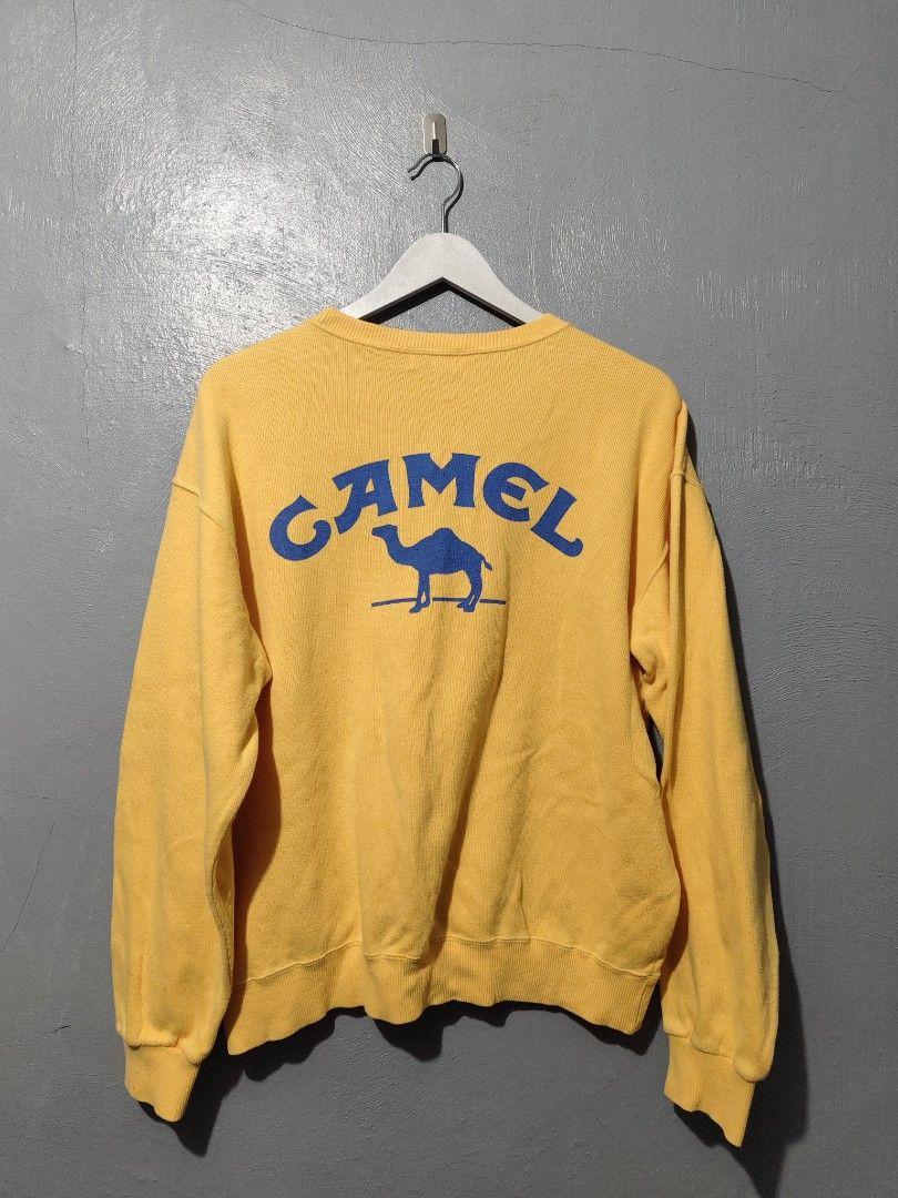 Vintage Camel Yellow Sweatshirt Blue Logo (Category: Coats, Jackets and Outerwear) located in Daet. Submitted by eezekethrift (Listing ID 1470071763, Image 2). Description: -brand: camel - Style: Vintage crew neck pullover sweatshirt - Color: Bright yellow with blue graphics on chest and back - Features: Soft fabric, ribbed cuffs and hem - Condition: Pre-loved, classic vintage piece.