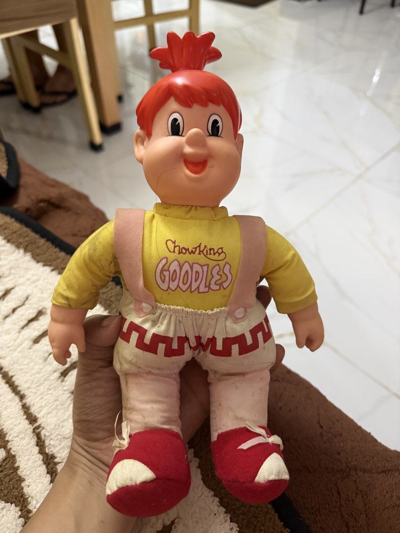 Vintage Chow King Goodles mascot plush doll (Category: Plushies & Soft Toys) located in Dasmarinas. Submitted by _adieeeee (Listing ID 1470029114, Image 1). Description: - Official Chowking Goodles promotional mascot doll - Design: Red plastic hair/head, yellow long-sleeve shirt with pink print, cream shorts with red hem, pink straps, and red shoes - Condition: Hard parts are fully intact - Note: Fabric shows minor dirt marks due to age and handl
