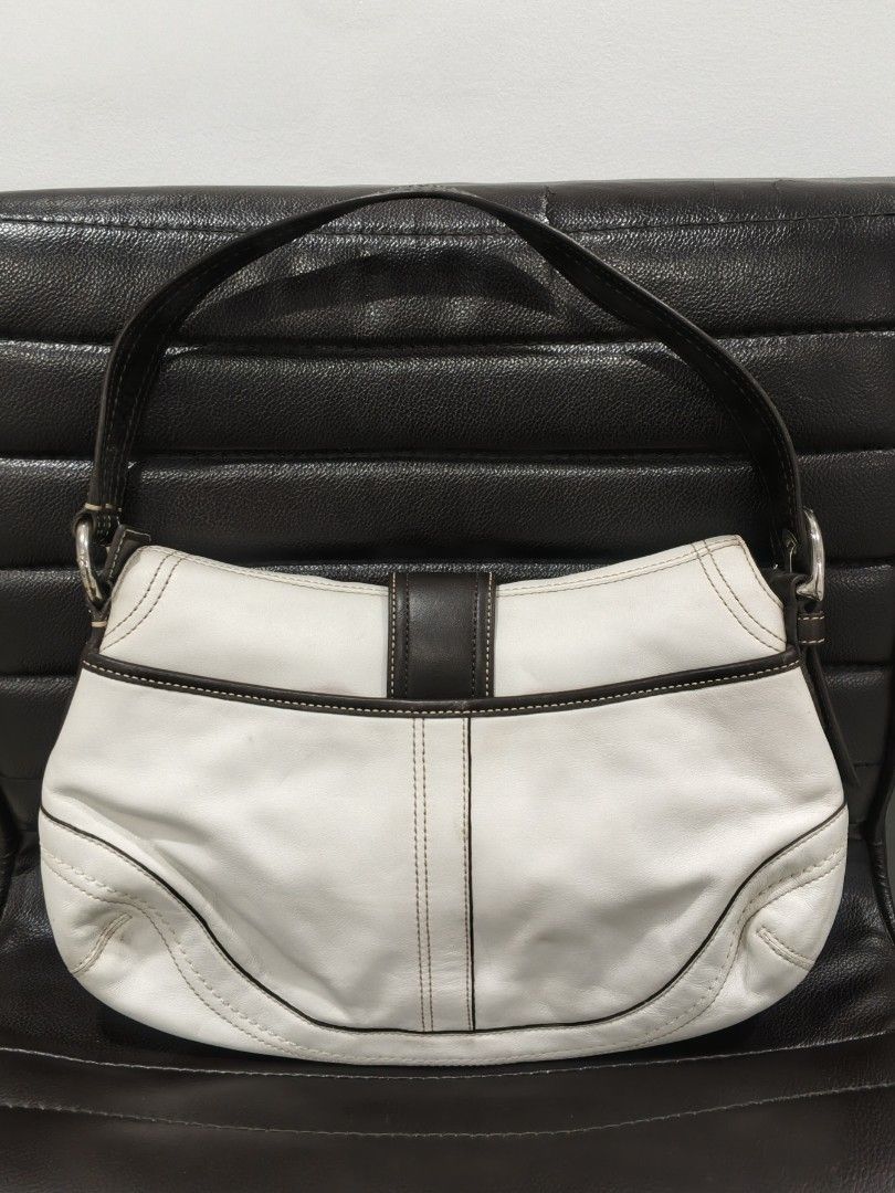 VINTAGE COACH SOHO SHOULDER BAG (Category: Shoulder Bags) located in Kabacan. Submitted by thriftedsupremacy11 (Listing ID 1469970647, Image 2). Description: Vintage Coach Soho Leather Flap Buckle Shoulder Bag (Model F10910), featuring a white leather body, a brown vertical center strap with a silver-tone buckle closure, and a dark brown shoulder strap. issue *leather stains*.