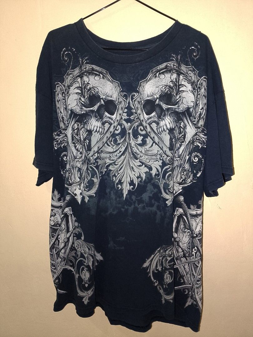 MMA Elite Vintage Skull Graphic Tee (Category: Tshirts & Polo Shirts ) located in Caloocan City. Submitted by ricecell (Listing ID 1469980450, Image 1). Description: - Dark blue graphic tee with a striking double skull and shield chest print - Detailed medieval scrollwork and swords on the lower front, sides, and back hem - Crew neck and short sleeves design - Features a heavy vintage fade and ultra-soft, worn-in fabric - Perfect for streetwear a