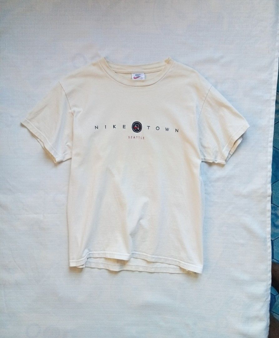 Vintage Nike Town Seattle roundneck tee (Category: Tshirts & Polo Shirts ) located in Bagabag. Submitted by thrift_stories96 (Listing ID 1470108515, Image 1). Description: Vintage Nike Town Seattle roundneck tee mens Small on tag fits medium crop boxy Length - 26.5 Width - 20.5 Condition - 8.5/10 Cream actual color Flaw - fade yellow stain sa right side laylayan..