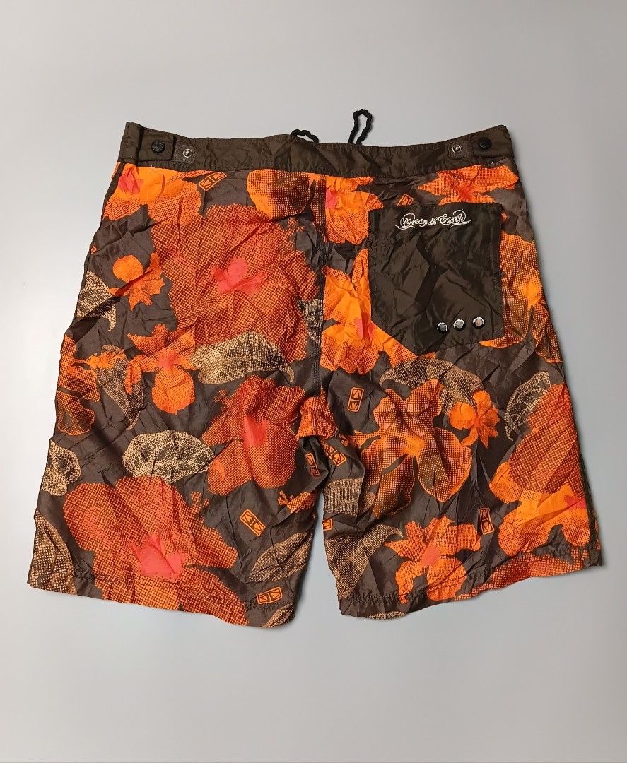 vintage Ocean & Earth board shorts (Category: Shorts) located in Manila. Submitted by hustler_777 (Listing ID 1470088250, Image 2). Description: Brand: Ocean and Earth Australia—a well-known, heritage Australian surf hardware and apparel brand established in 1979. Design: An all-over abstract Hawaiian/hibiscus floral print combining a textured orange overlay against a deep dark brown or charcoal base. Hardware & Features: A contrasting dark brown