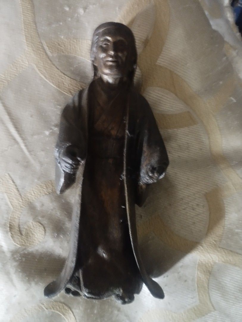 Vintage solid brass statue 1960s era (Category: Figurines & Statues) located in Mandaluyong City. Submitted by LEATHERFACE (Listing ID 1469972313, Image 1). Description: - Type: Solid metal statue of a person in a traditional robe - Finish: Dark patina all over - Size: Roughly 8 inches tall - Weight: Heavy, feels like cast iron or bronze - Features: Detailed facial expression and flowing garments, stands upright on its own - Origin: Found during 