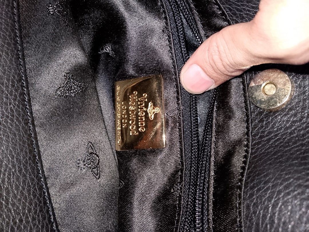 Vivienne Westwood Black Leather Bag (Category: Luxury Bags & Wallets) located in Manila. Submitted by mjthrifted_second (Listing ID 1469975704, Image 3). Description: - Brand: Vivienne Westwood London - Material: Genuine black pebble leather, Made in Italy - Hardware: Gold tone with metal logo plaque - Closure: Secure magnetic snap - Interior: Patterned satin lining with a zip compartment - Design: Structured bottom with sturdy twin grab handles.