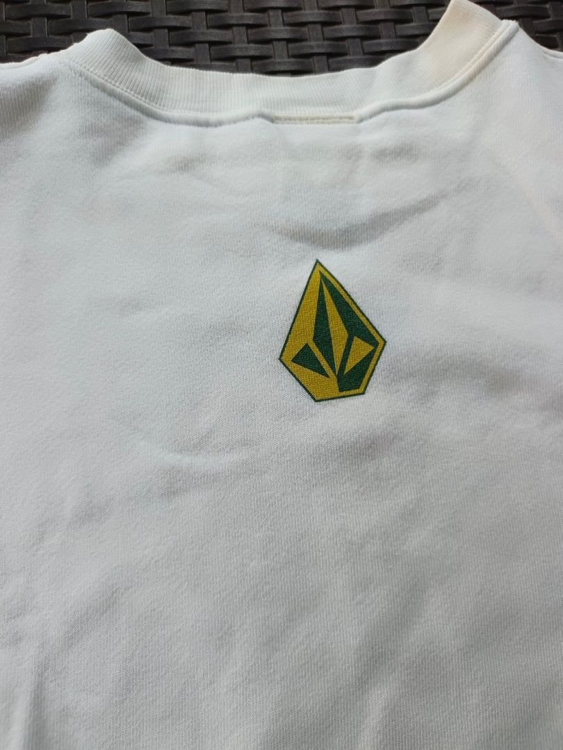 Volcom White Sweatshirt with Green Logo (Category: Coats, Jackets and Outerwear) located in Currimao. Submitted by jerson120 (Listing ID 1470066759, Image 3). Description: - Brand: Volcom - Style: Classic crewneck pullover - Color: White - Details: Embroidered green & yellow stone logo on front, printed logo on sleeve - Fit/Finish: Ribbed neckline and cuffs - Condition/Vibe: Great everyday piece for skating or casual streetwear.