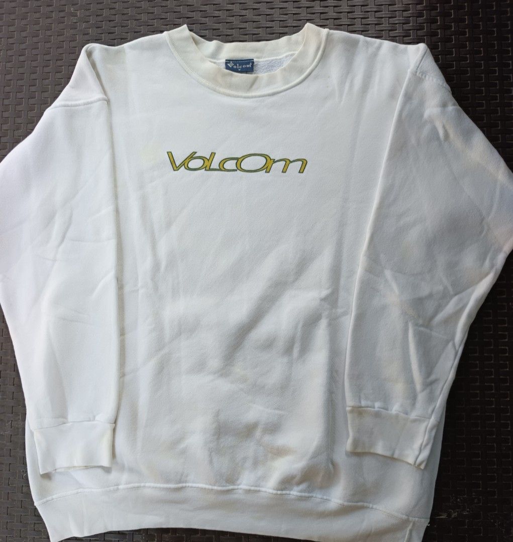 Volcom White Sweatshirt with Green Logo (Category: Coats, Jackets and Outerwear) located in Currimao. Submitted by jerson120 (Listing ID 1470066759, Image 1). Description: - Brand: Volcom - Style: Classic crewneck pullover - Color: White - Details: Embroidered green & yellow stone logo on front, printed logo on sleeve - Fit/Finish: Ribbed neckline and cuffs - Condition/Vibe: Great everyday piece for skating or casual streetwear.