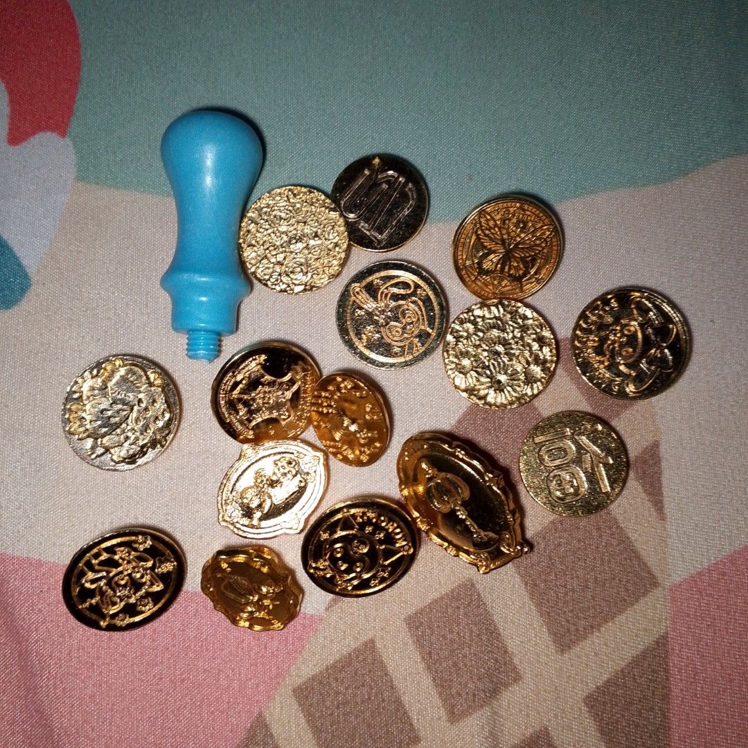 Wax seal stamp handle with multiple brass heads (Category: Craft Supplies & Tools) located in Makati City. Submitted by meghantherobot (Listing ID 1470112554, Image 1). Description: - Complete wax seal stamp kit - Includes blue plastic handle with screw thread - Comes with around 15 assorted brass stamp heads (flowers, butterflies, animals, symbols) - Easy to swap and use - Ideal for DIY crafts, journaling, and sealing letters.