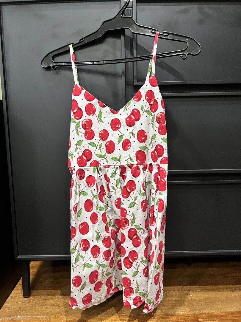 White cherry print spaghetti strap top / dress (Category: Dresses) located in Manila. Submitted by charmssin75605 (Listing ID 1470001705, Image 1). Description: - Style: White summer dress with red cherry and green leaf print - Design: V-neckline, thin spaghetti straps, and a flattering pleated waistline - Material: Lightweight and breathable cotton - Perfect for: Warm weather days, picnics, and casual outings.
