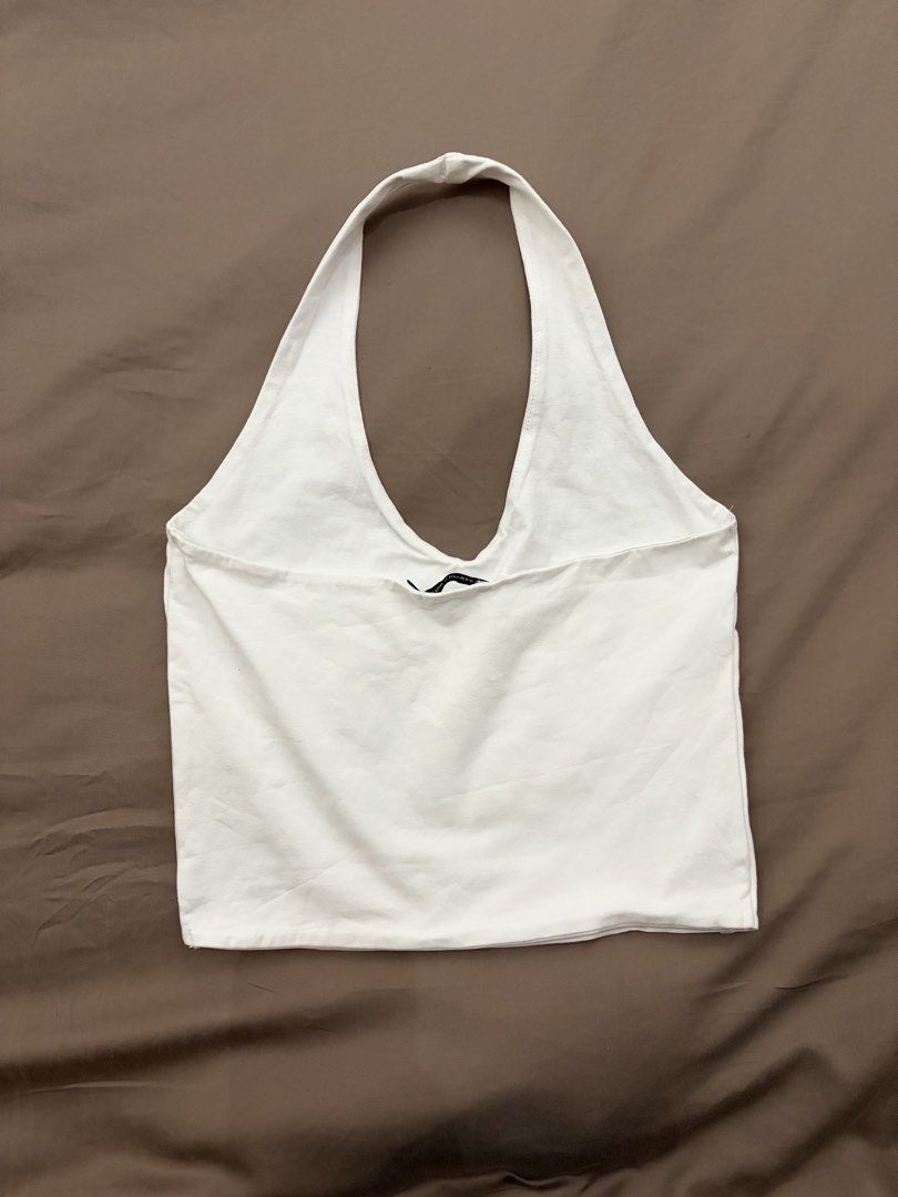 White Halter Top (Category: Sleeveless) located in Pasig City. Submitted by gdeclutterwithme (Listing ID 1470115717, Image 2). Description: - Brand: Stradivarius - Size: M (fits EUR, USA, MEX) - Color: White - Style: Classic minimalist halter top with deep scoop neckline and back, thick shoulder straps - Material: Soft cotton fabric - Versatility: Easy to style with high-waisted jeans or skirts dm for more deets!.