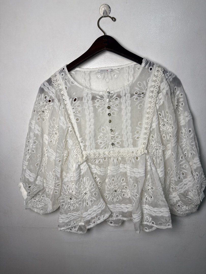 JESSICA White Lace Embroidered Blouse (Category: Blouses) located in Quezon City. Submitted by dropdeadprices (Listing ID 1470078765, Image 1). Description: - Brand/Label: Jessica Red - Size: P - Color: White (sheer) - Details: Cutwork embroidery, floral patterns, textured panels - Neckline & Closure: Round neck with mother-of-pearl style front buttons - Sleeves: Relaxed three-quarter length - Condition: Clean and well-kept.