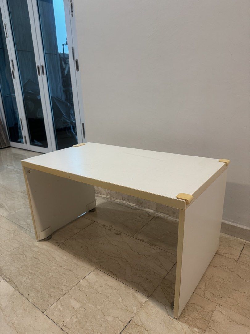 White Table (Category: Tables & Sets) located in Singapore. Submitted by kohkacola (Listing ID 1470139677, Image 1). Description: Length - 90cm Breath -50cm Height -50cm - Colour/Shape: White, simple rectangular coffee table - Build: Sturdy solid panel legs, standard living room height - Safety: Yellow corner guards installed on all four corners - Condition: Minor surface wear on top - Maintenance: Easy to wipe clean and fits most room layouts.