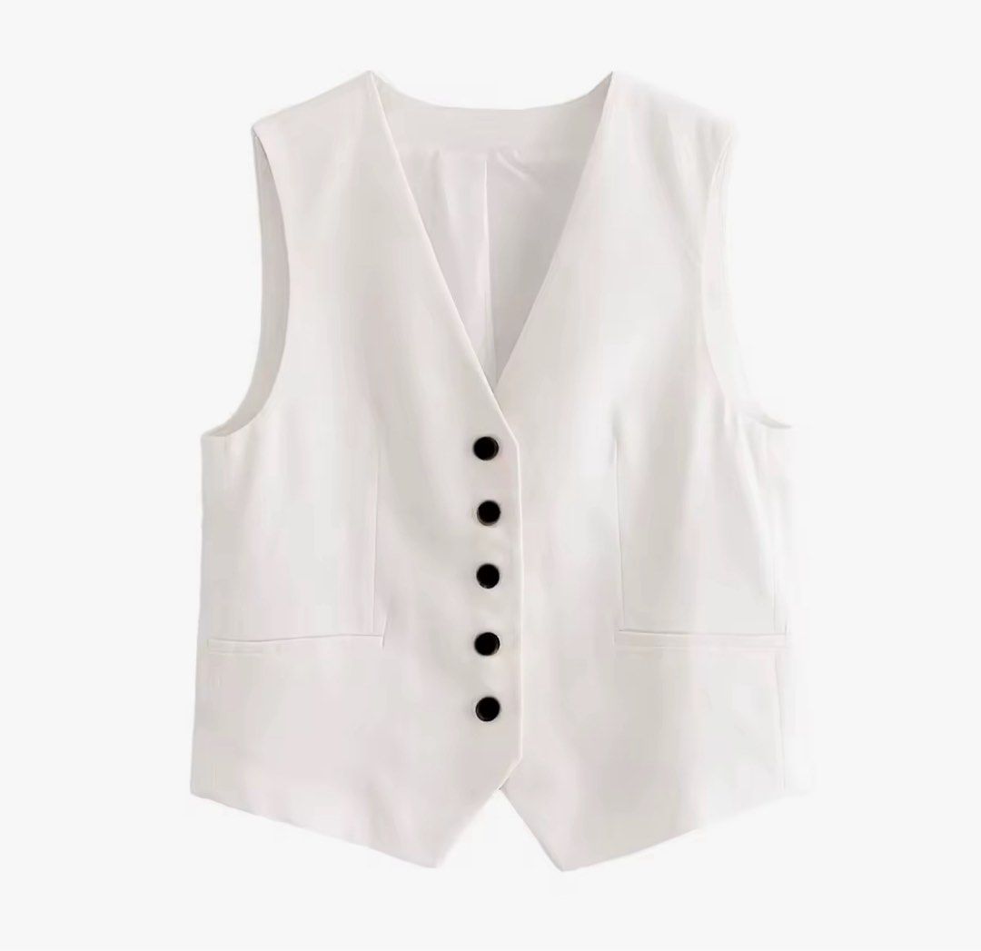 White Button Front V-Neck Vest Waistcoat (Category: Coats, Jackets and Outerwear) located in Taguig. Submitted by marie133 (Listing ID 1470117212, Image 1). Description: - Color: Crisp white with contrasting black buttons - Style: Sleeveless V-neck vest with a chic pointed hem - Features: Two front pockets, fully lined interior, tailored fit - Sizes: Available in XS and S (refer to size chart for chest and length) - Versatility: Perfect layering 