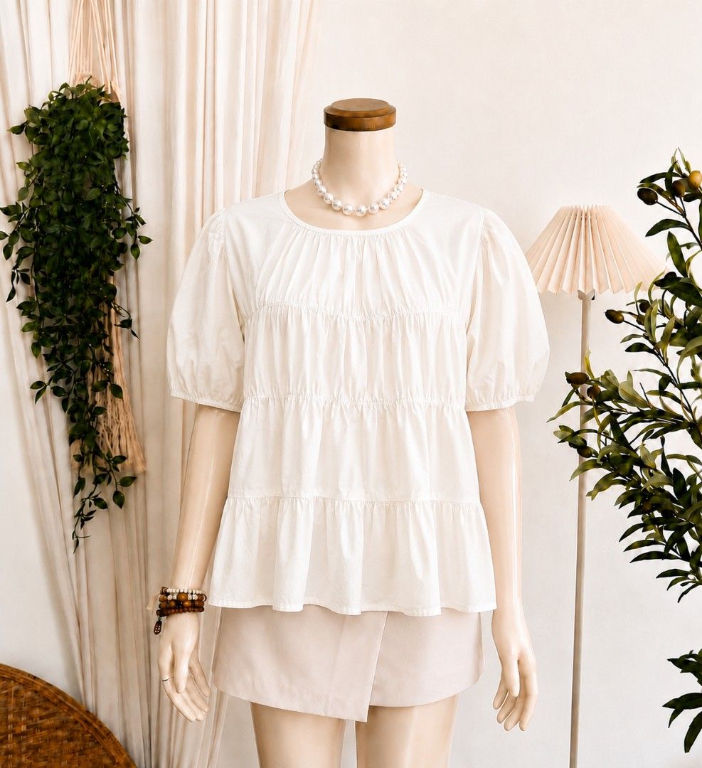 White Tiered Short Sleeve Blouse Peasant Top (Category: Blouses) located in Cebu City. Submitted by smnthdanielle (Listing ID 1470128475, Image 1). Description: - Color: White - Style: Casual short sleeve blouse with tiered design and gathered details - Neckline: Round neckline - Sleeves: Trendy puffy sleeves - Fit: Soft fabric that falls loosely for comfort - Pairing: Easy to match with shorts or skirts for warm weather outings.