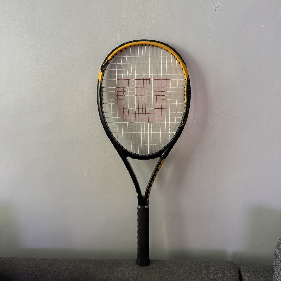 Wilson Hyper Hammer Legacy Mid Tennis Racket (Category: Racket and Ball Sports) located in Dinalupihan. Submitted by alexenaaajame (Listing ID 1470000198, Image 1). Description: - Model: Wilson Hyper Hammer Legacy Mid tennis racket - Design: Classic black and yellow frame - Strings: Strung with white strings featuring the red Wilson logo - Grip: Standard handle wrapped in black tape RFS: Switch to Pickleball Bought From Chris Sports.