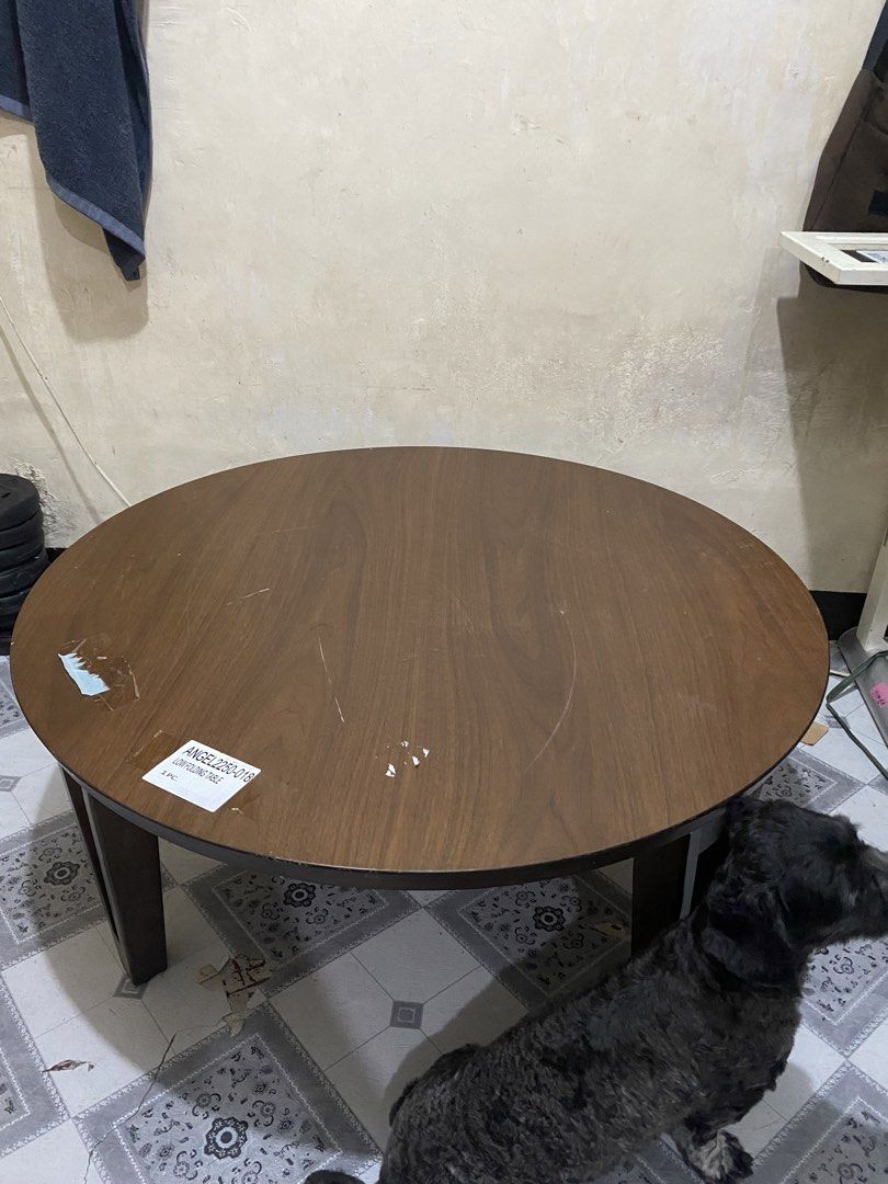 Wood Round Table 🏷️🏷️ (Category: Tables & Sets) located in Quezon. Submitted by odd.theprelovedhub (Listing ID 1469978693, Image 1). Description: Wood Round Table 🏷️🏷️ • Color: Dark Brown • Material: Natural Wood Fiber Wood • Dimensions: (Width 900 × Height 350 mm) • Folding Leg • With visible sign of use Folding Instructions- Push the lock on the leg mounting hardware while folding the leg down in the direction of the arrow until it locks se